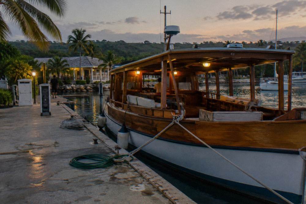 A wooden tour boat resting at a marina dock before a night trip