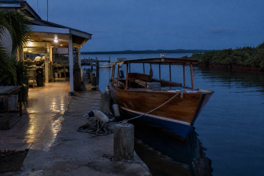 Wooden tour boat moored at a marina dock at dusk