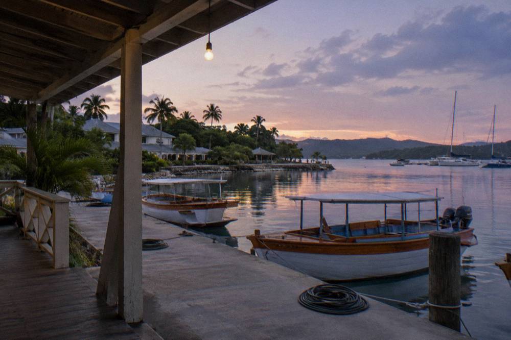 Wooden tour boat moored at a marina dock at dusk