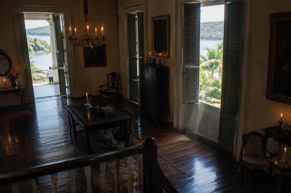A candlelit Georgian interior with dark wood floors and antique furniture
