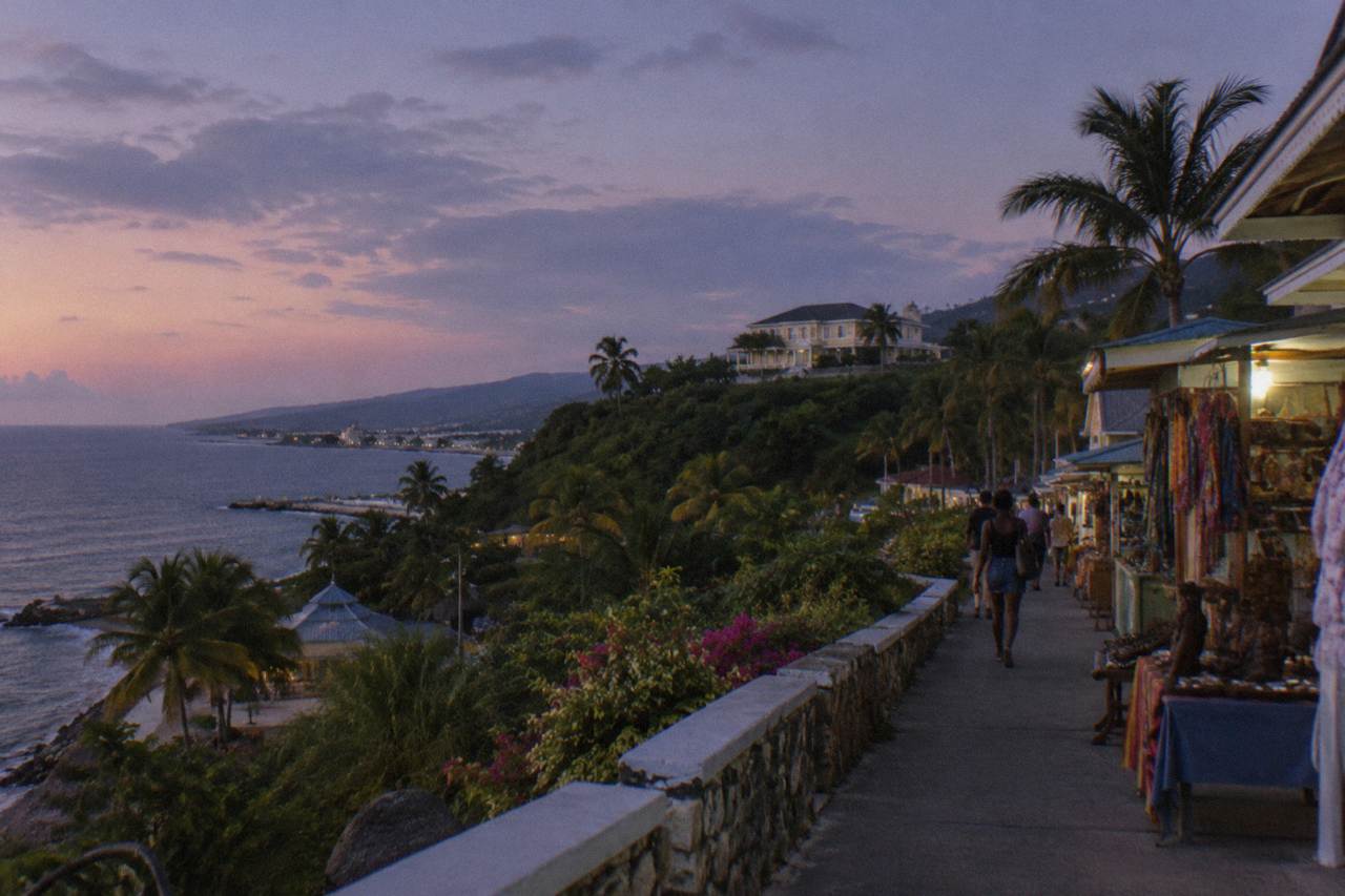 A Georgian great house on a green hillside above the Caribbean coast at dusk