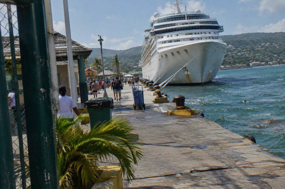 A cruise ship docked at a Caribbean port pier in bright morning light