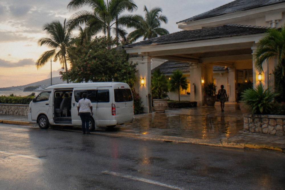 Hotel lobby entrance at dusk with a tour minivan waiting