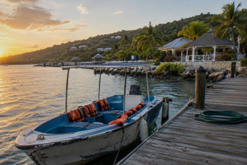 A small tour boat with life vests stowed along its seats moored at a wooden dock