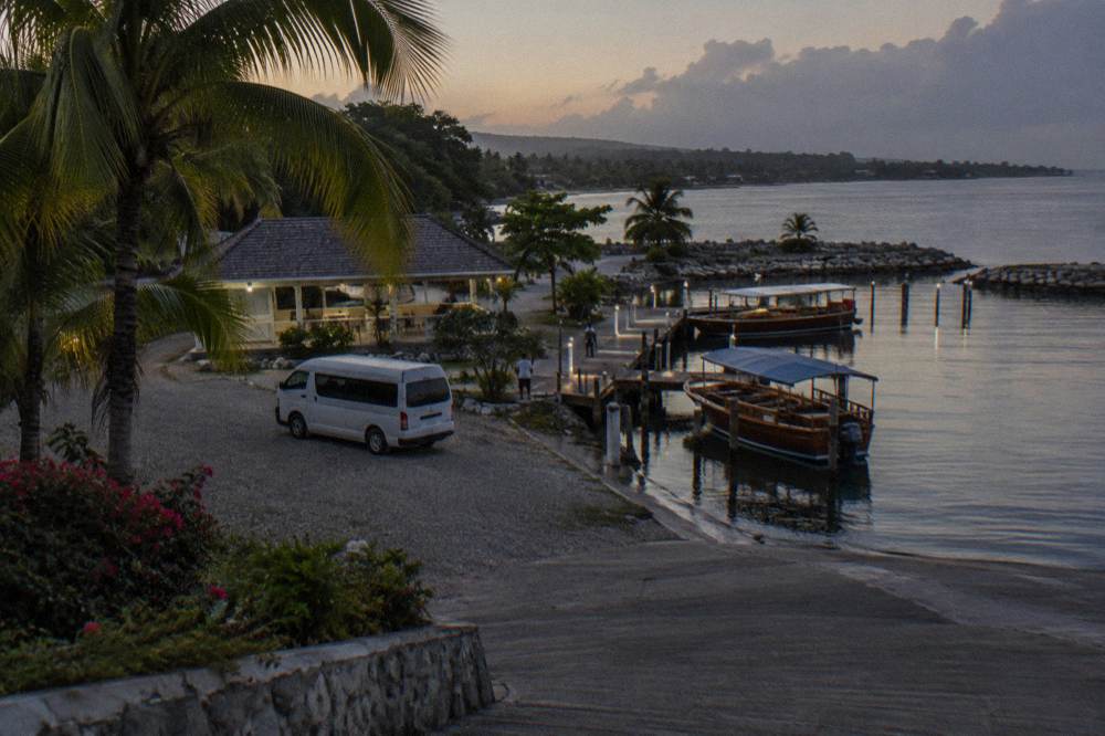 Van parked at a marina dock with boats waiting in darkness