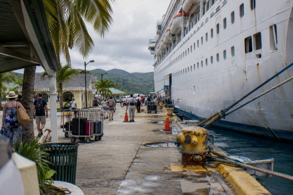 A cruise ship docked at a pier in late afternoon light
