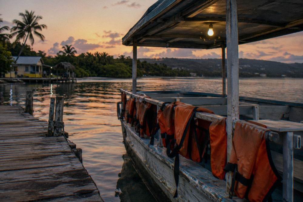 Life jackets hanging on railings inside an open tour boat at a wooden dock