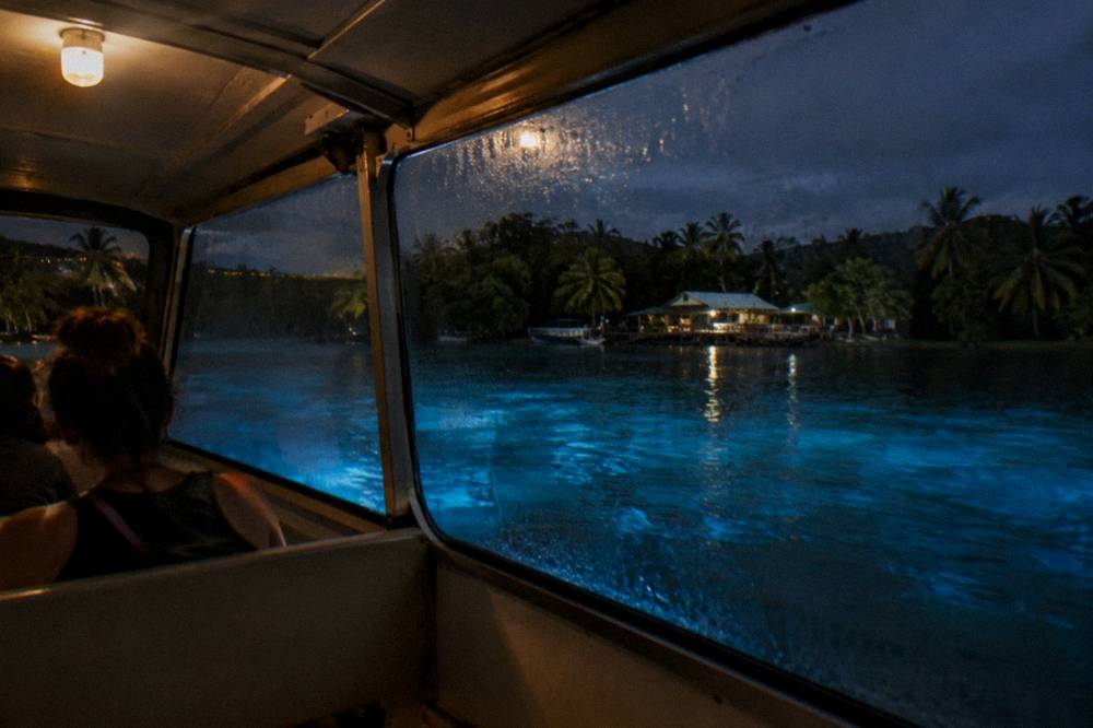 Folded dark towels and a waterproof bag on a boat seat under dim cabin light